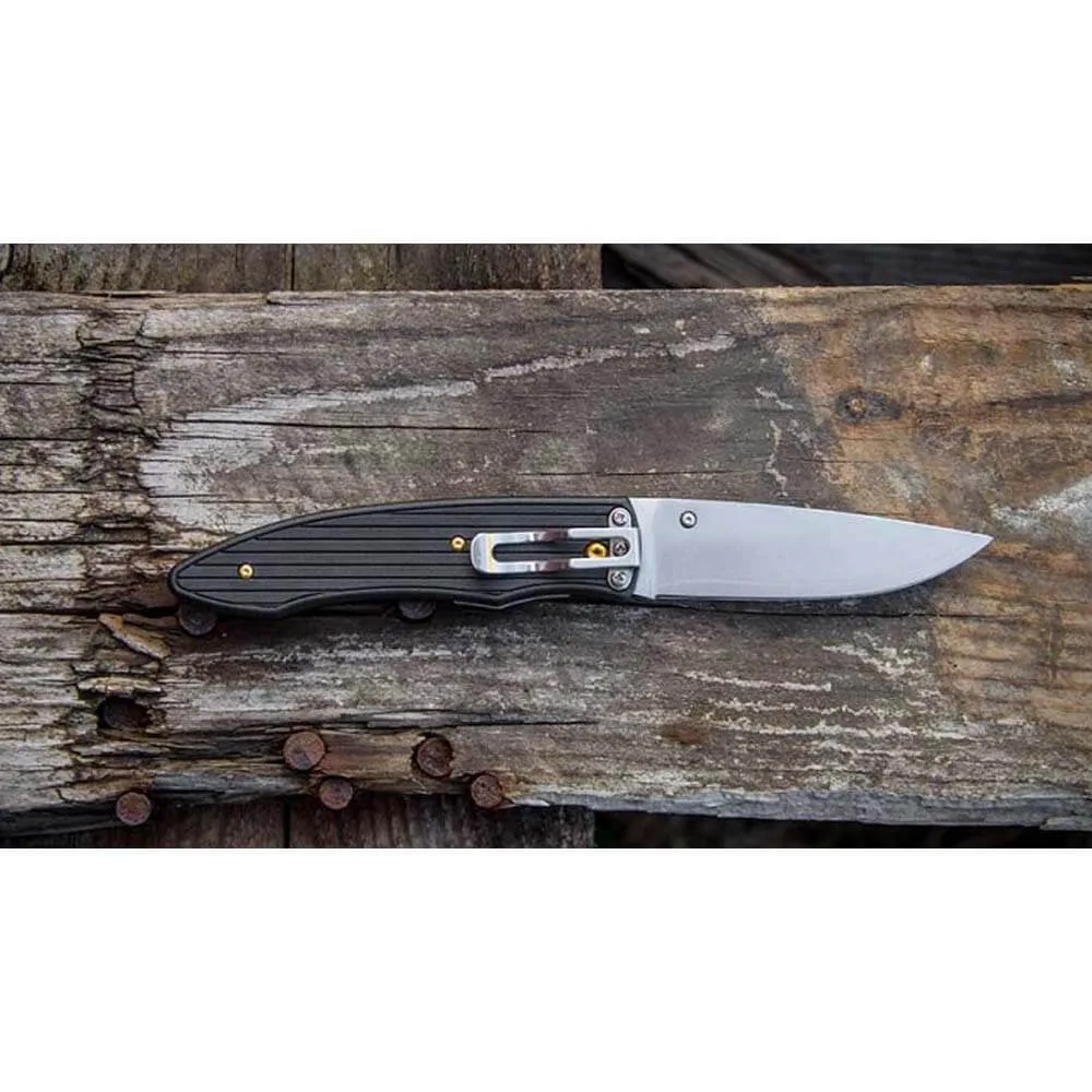 Fällkniven PCx i laminerat koboltspecialstål ligger på en träbräda.