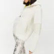 Röhnisch Wazzi Pile Hoodie, på en brunhårig modell som står åt sidan