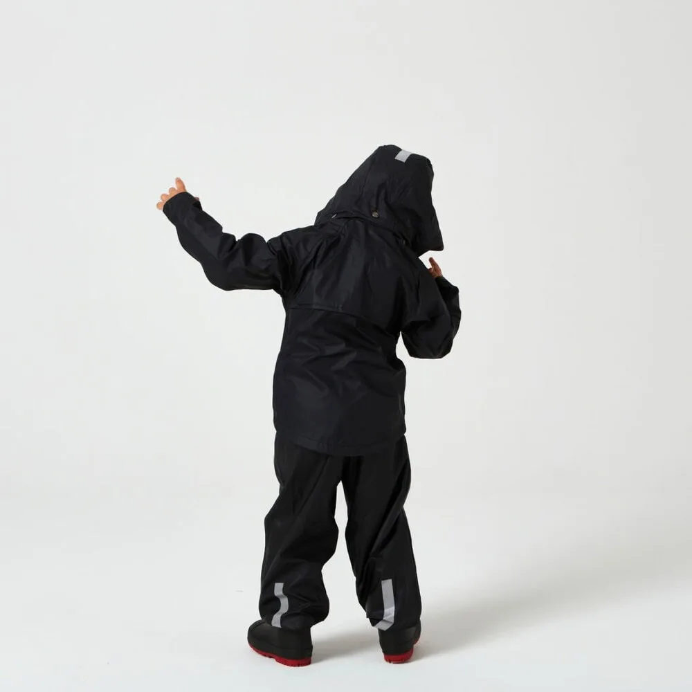 En pojke har påp sig Tretorn Kids Packable rainset och står och dansar