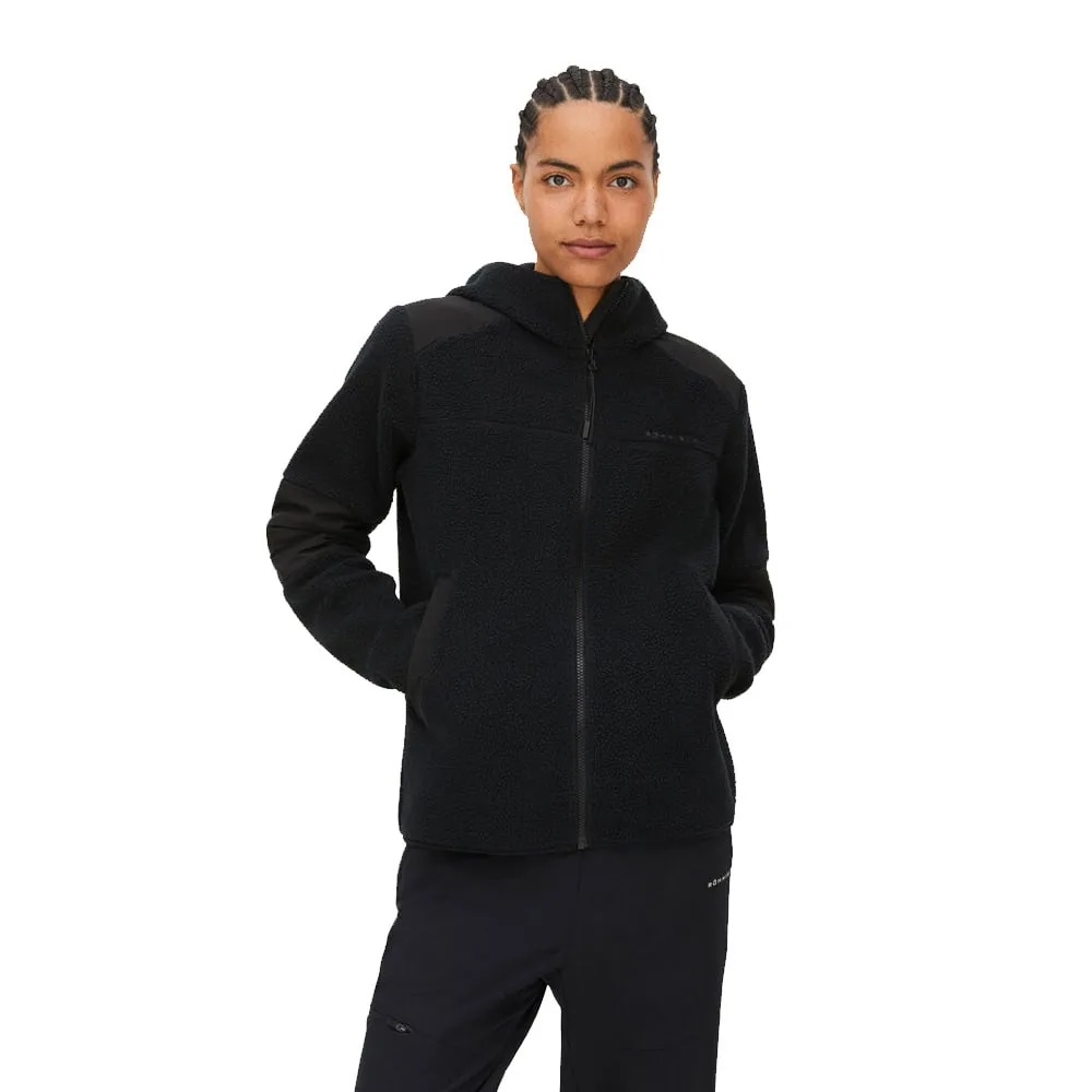 Röhnisch Wazzi Pile Hoodie, svart på en modell som står mot kameran