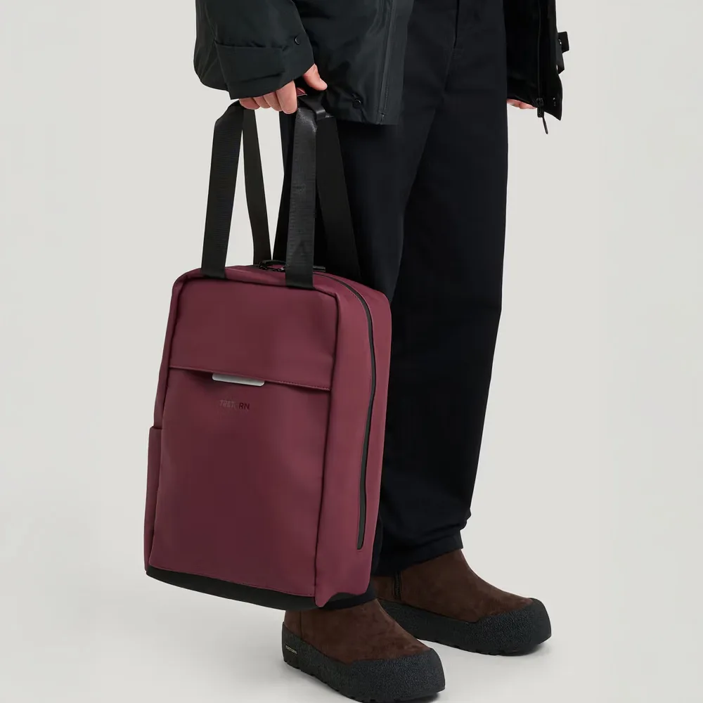 en person håller i en Tretorn Wings Flexpack vattenavisande ryggsäck (unisex)