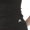 En modell bär Adidas Tank Top linne (dam) och man ser loggan