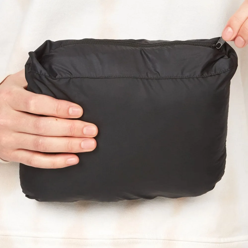 En nerpackad Marmot Guides Down Vest dunväst (dam) som någon håller i med två händer