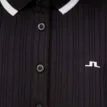 Närbild på knäppning och logga på J.Lindeberg Moira Polo retro pikétröja (dam)
