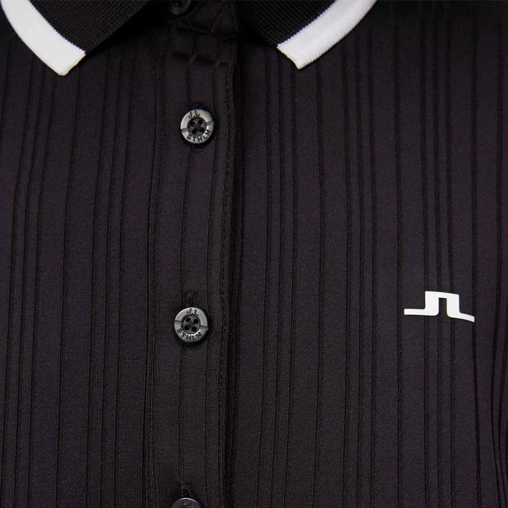 Närbild på knäppning och logga på J.Lindeberg Moira Polo retro pikétröja (dam)