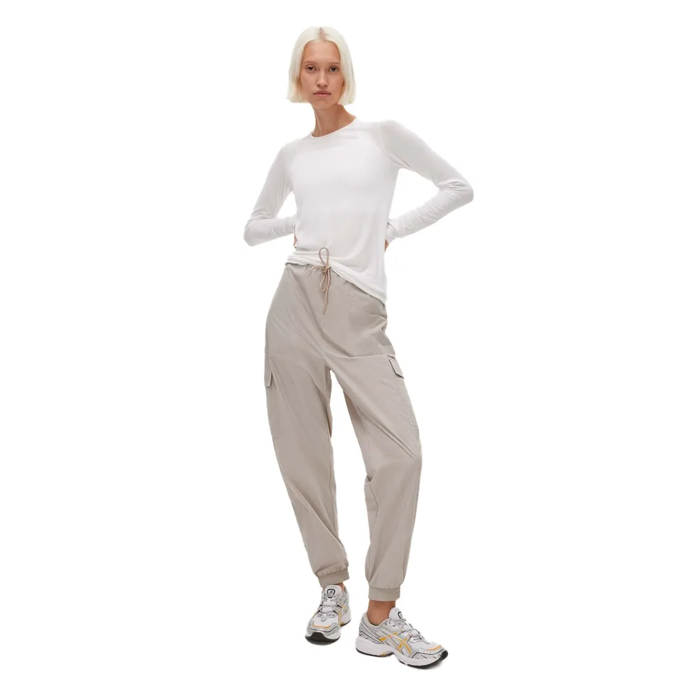 En modell bär ett par Sköna och skyddande Röhnisch Frankie Wind Pants vindbyxor (dam)
