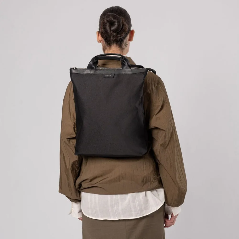 En modell bär En stilren men mångfunktionell Sandqvist Beenie Twill 15L på ryggen