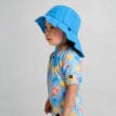 ett barn bär en Reima Sunhat Rantsu solhatt (barn)
