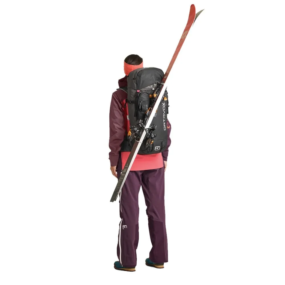 En modell har på sig Ortovox Peak 32L S vandringsryggsäck (unisex) med skidor