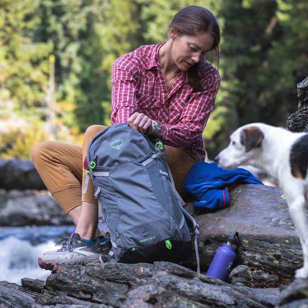 en kvinna använder Osprey Sportlite 25 dagsryggsäck (unisex)