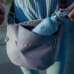 en person använder vattenflaska i en Osprey Daylite Crossbody Pouch axelväska (unisex)