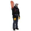 en man bär en Osprey Glade 12 skidryggsäck (unisex) med en snowboard