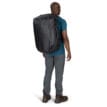 en manlig modell har på sig en Osprey Transporter Duffel 65L (unisex)