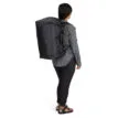 en modell har Osprey Transporter Squffel 44L resväska (unisex) på ryggen