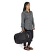 en modell bär Osprey Transporter Squffel 44L resväska (unisex) som en väska