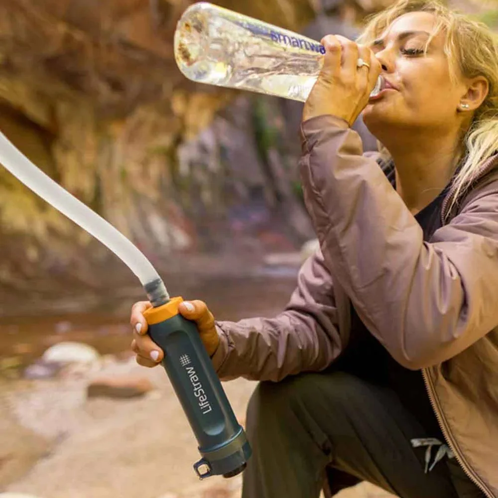 Kvinna som dricker vatten med Lifestraw Peak Series Gravity Water Purifier System 8 L