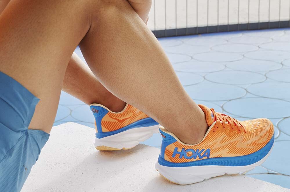 en man bär ett par HOKA Clifton 9 Wide löparskor