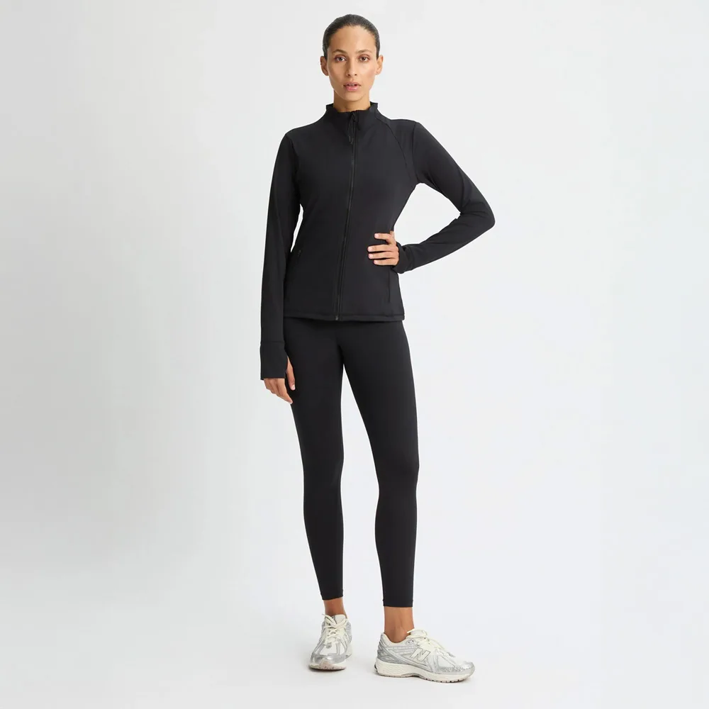en modell bär en stängd Röhnisch Legacy Full Zip träningströja (dam)