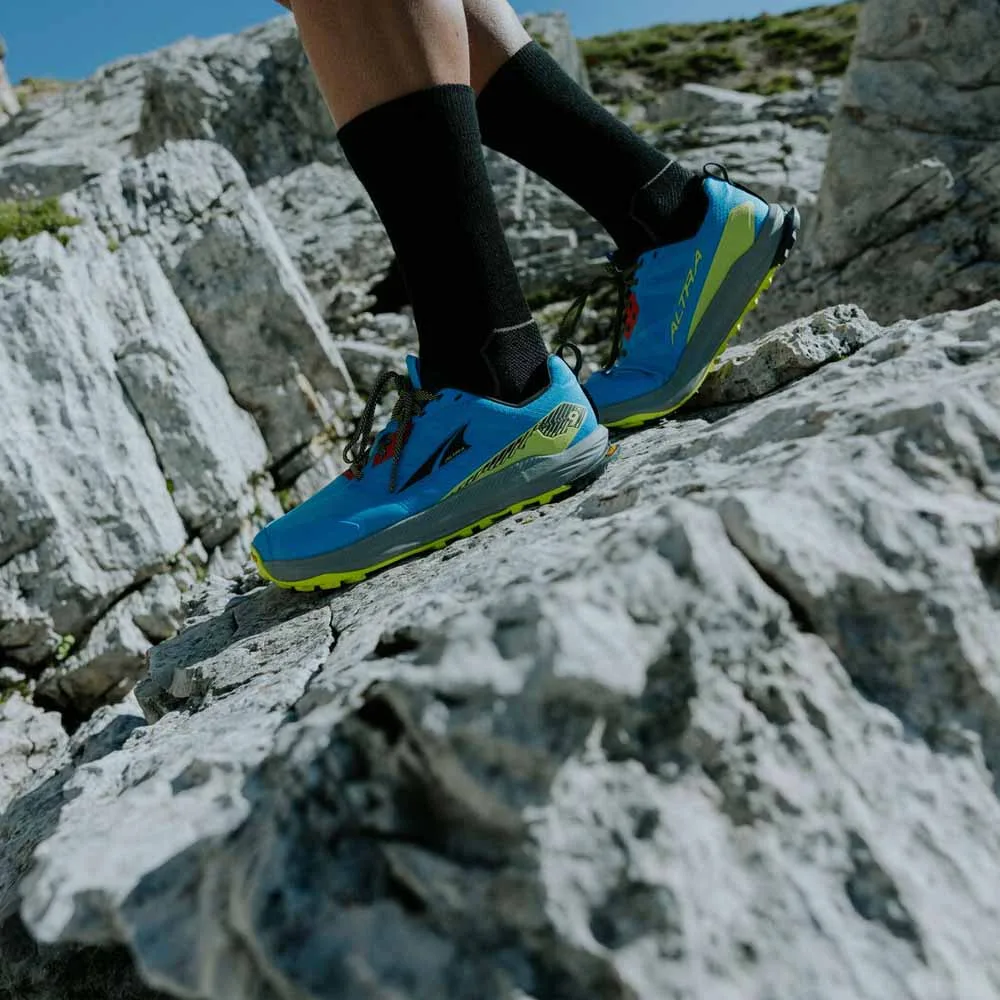 en modell använder Altra Lone Peak 9+ traillöparskor (herr) på klippor