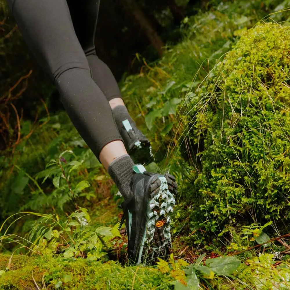 en modell använder Altra Lone Peak 9+ traillöparskor (dam) i en skog