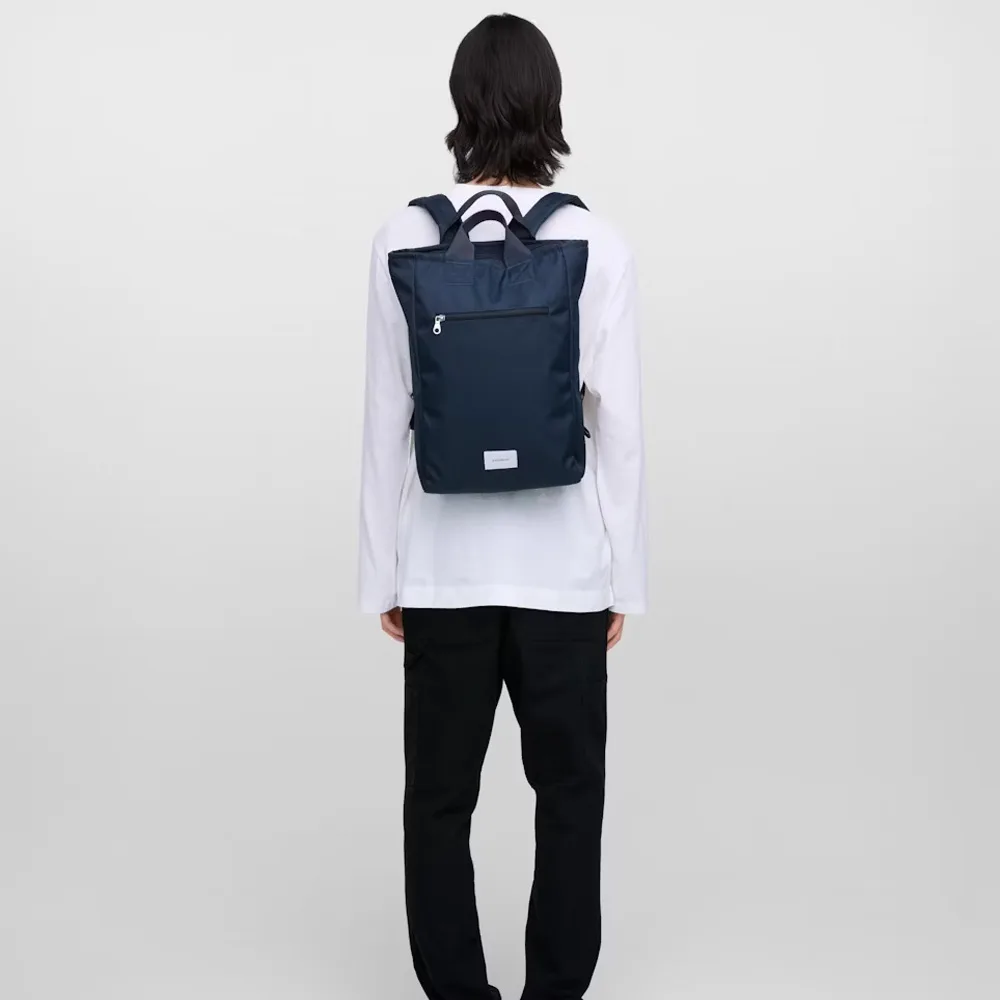 en man bär en Sandqvist Ground 2-Way Bag väska (unisex)