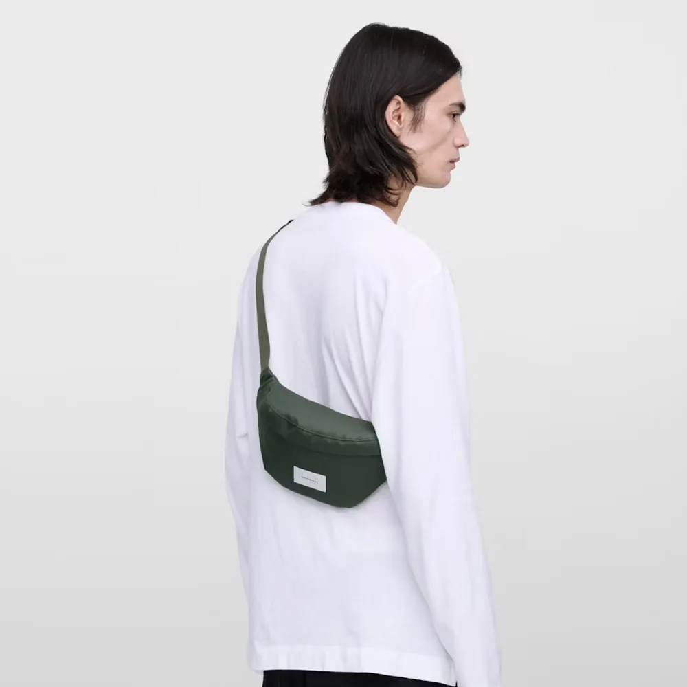 en modell bär en Sandqvist Ground Crossbody Bag axelväska (unisex)