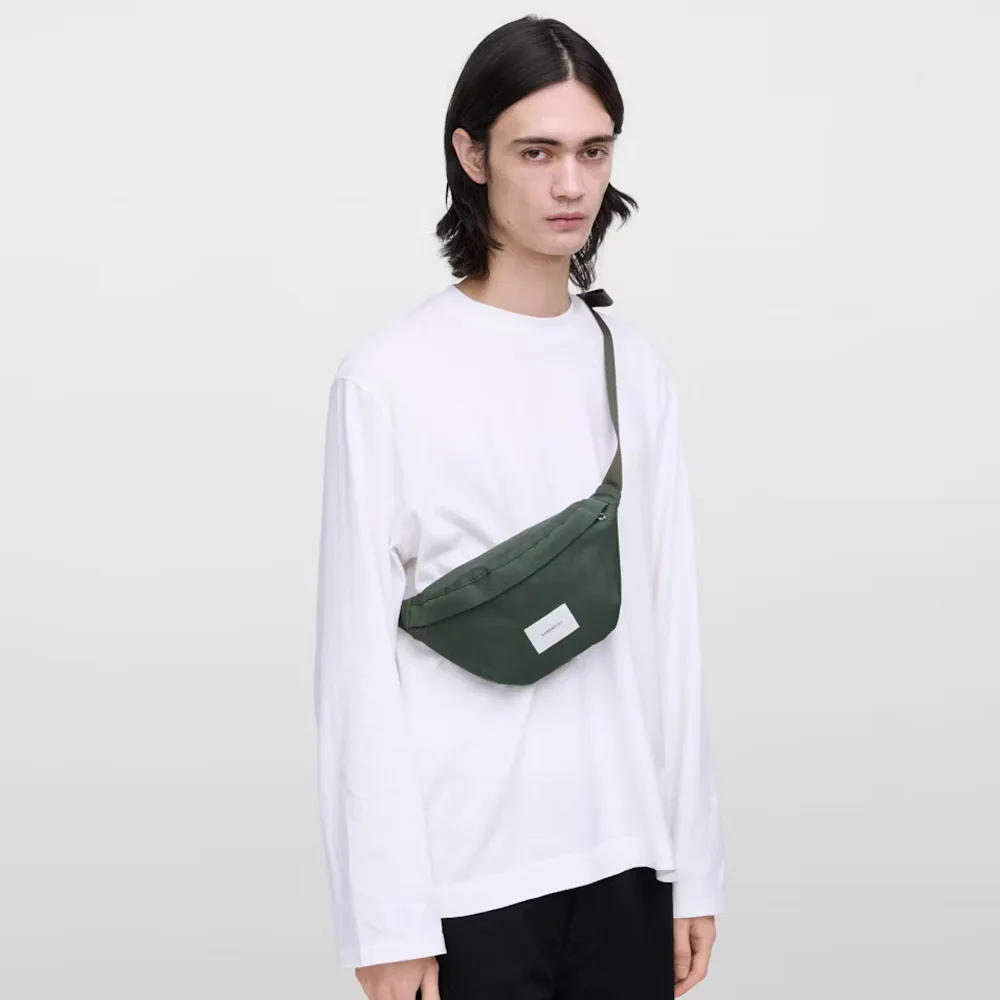 Sandqvist Ground Crossbody Bag axelväska (unisex) på en man