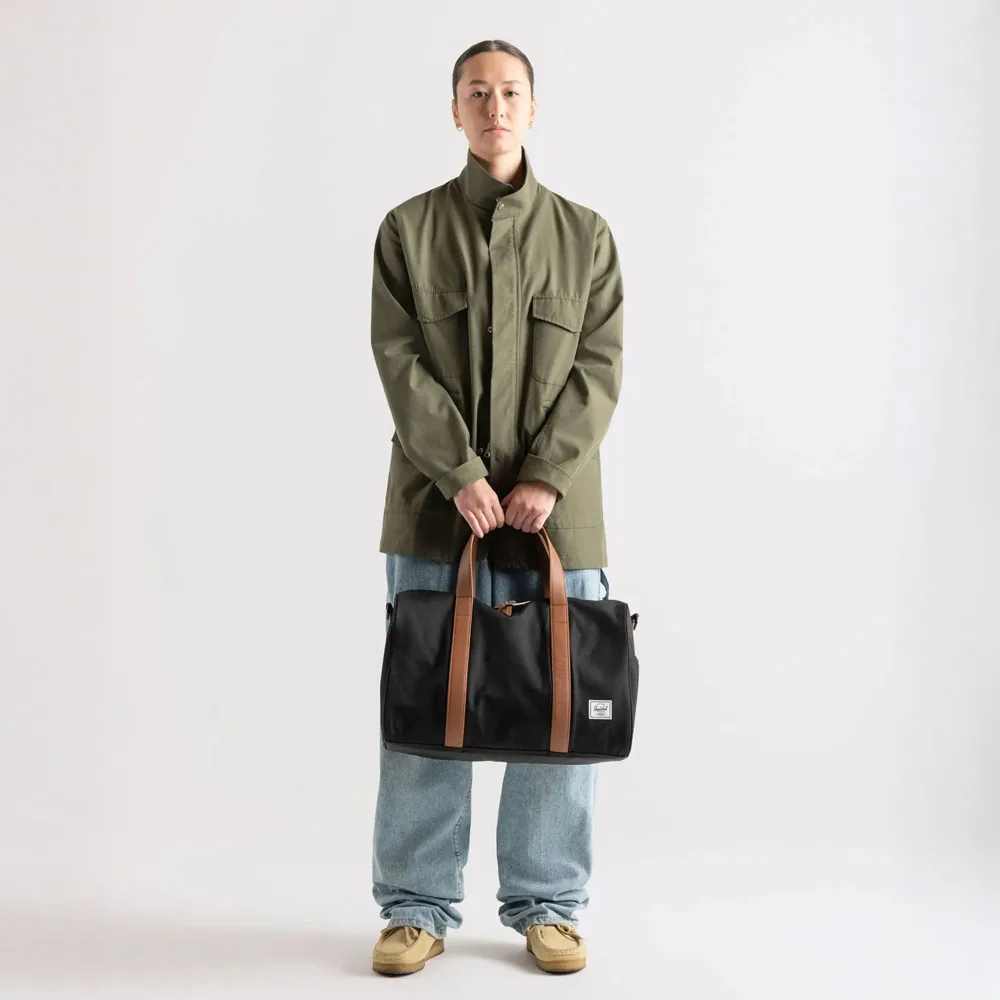 en kvinnlig modell bär Herschel Novel Carry On Duffle väska 26,5 L (unisex)