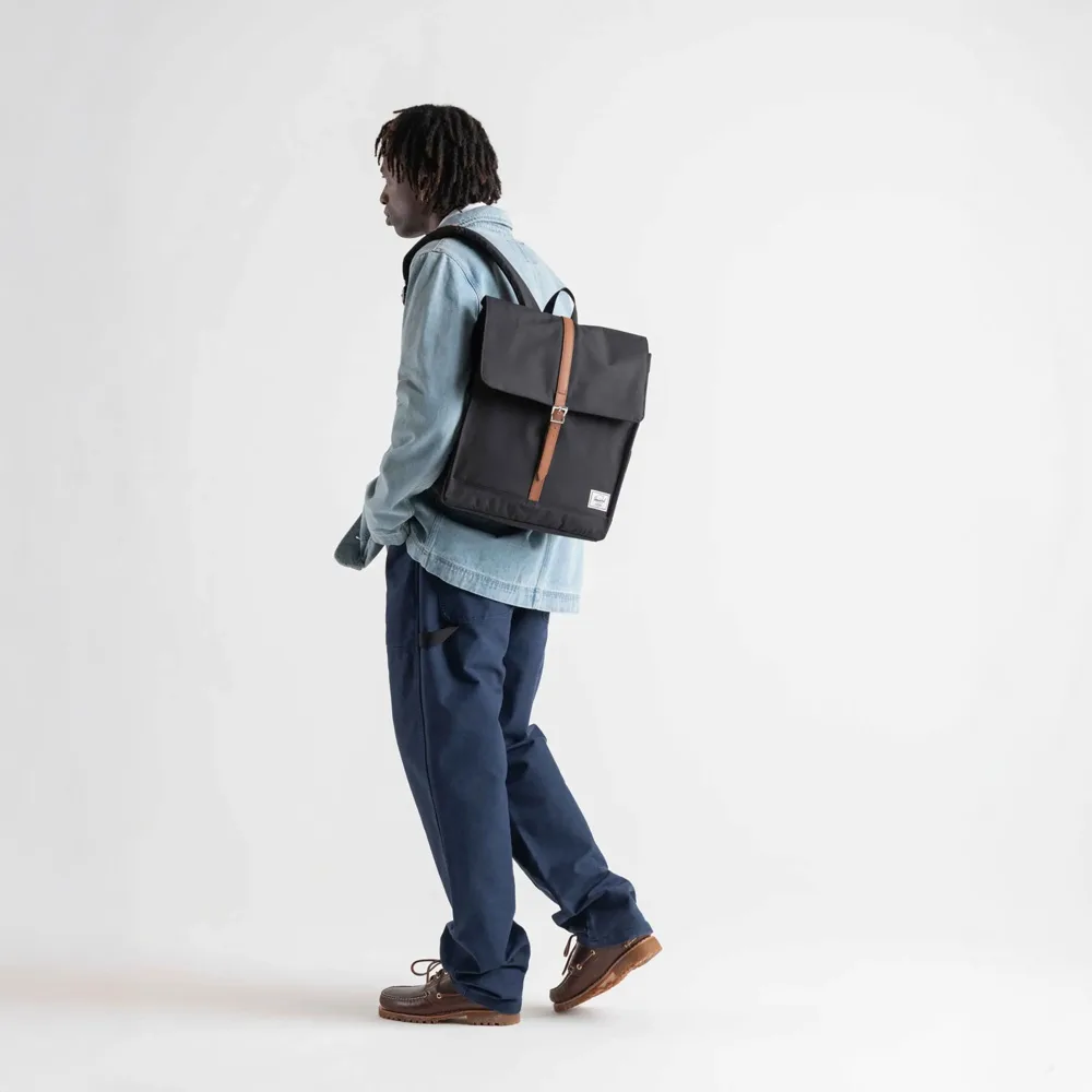 en man bär Herschel City vardagsryggsäck 16 L (unisex)