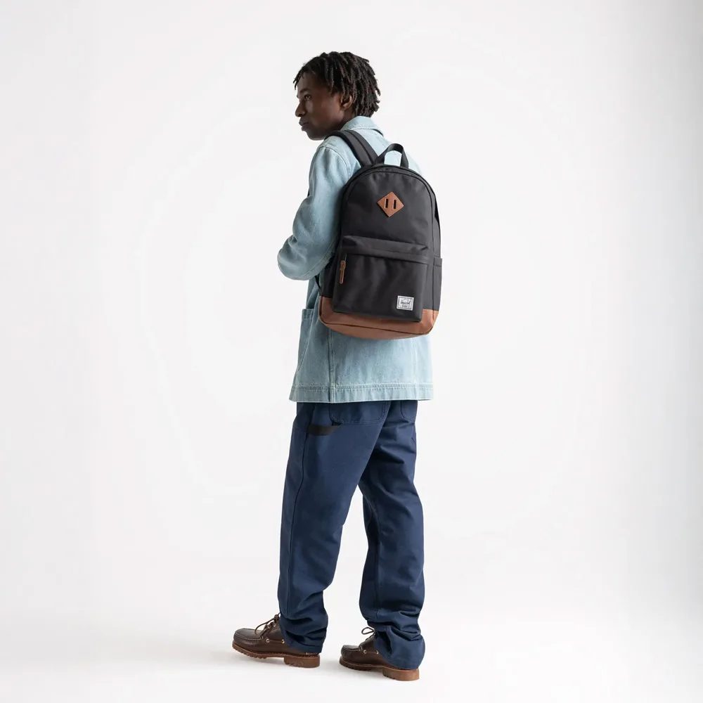 en manlig modell bär Herschel Heritage 24 L vardagsryggsäck (unisex)