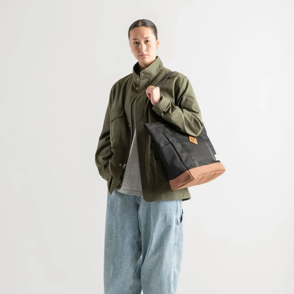 en kvinna bär Herschel Heritage Tote väska 24,5 L (unisex)