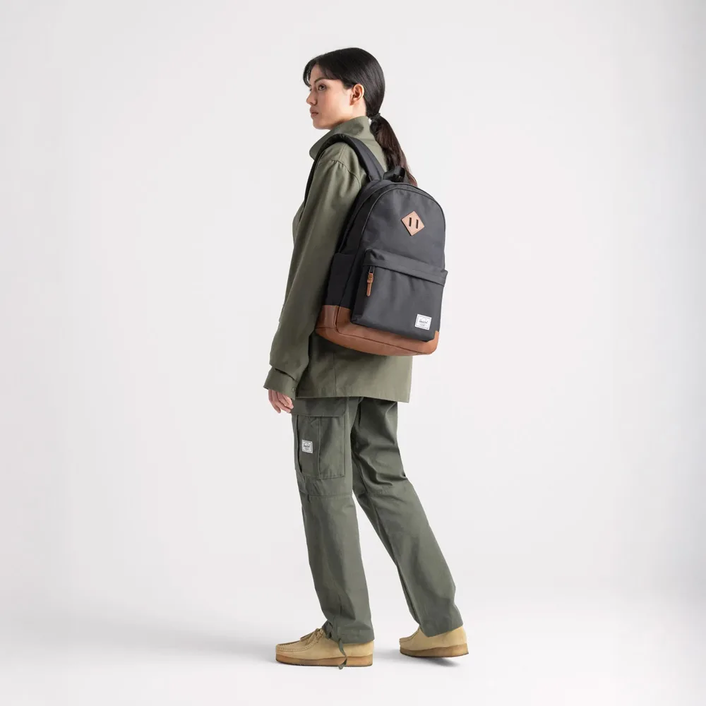 en kvinnlig modell bär Herschel Heritage 24 L vardagsryggsäck (unisex)