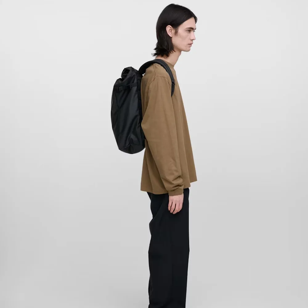en modell bär en Sandqvist Stream Slim Rolltop L 26 L dagsryggsäck (unisex)