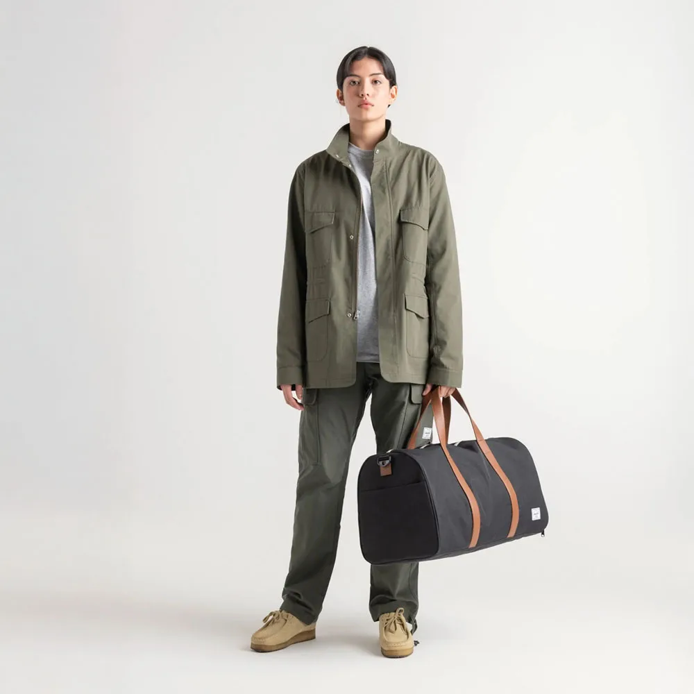 en person håller en Herschel Novel Duffle 43 L bag (unisex)