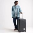 person som håller i Herschel Heritage Hardshell Medium Luggage 67 L resväska (unisex)
