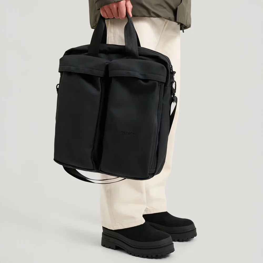 en person håller i en Tretorn Wings Shoulder Tote väska (unisex)