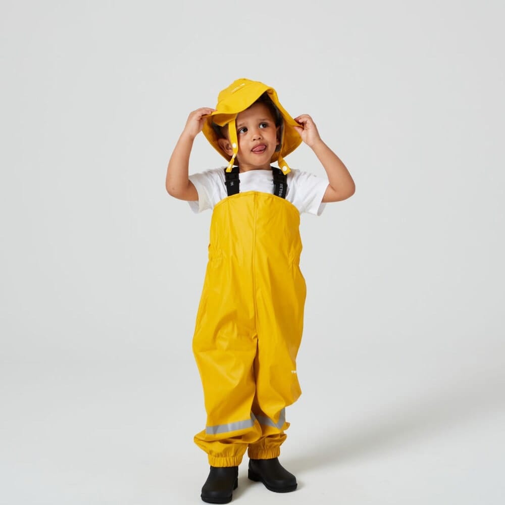 en pojke bär Tretorn Kids Wings High Rainpants regnbyxor (barn)