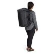 en kvinna bär Osprey Transporter Squffel 70L resväska (unisex)