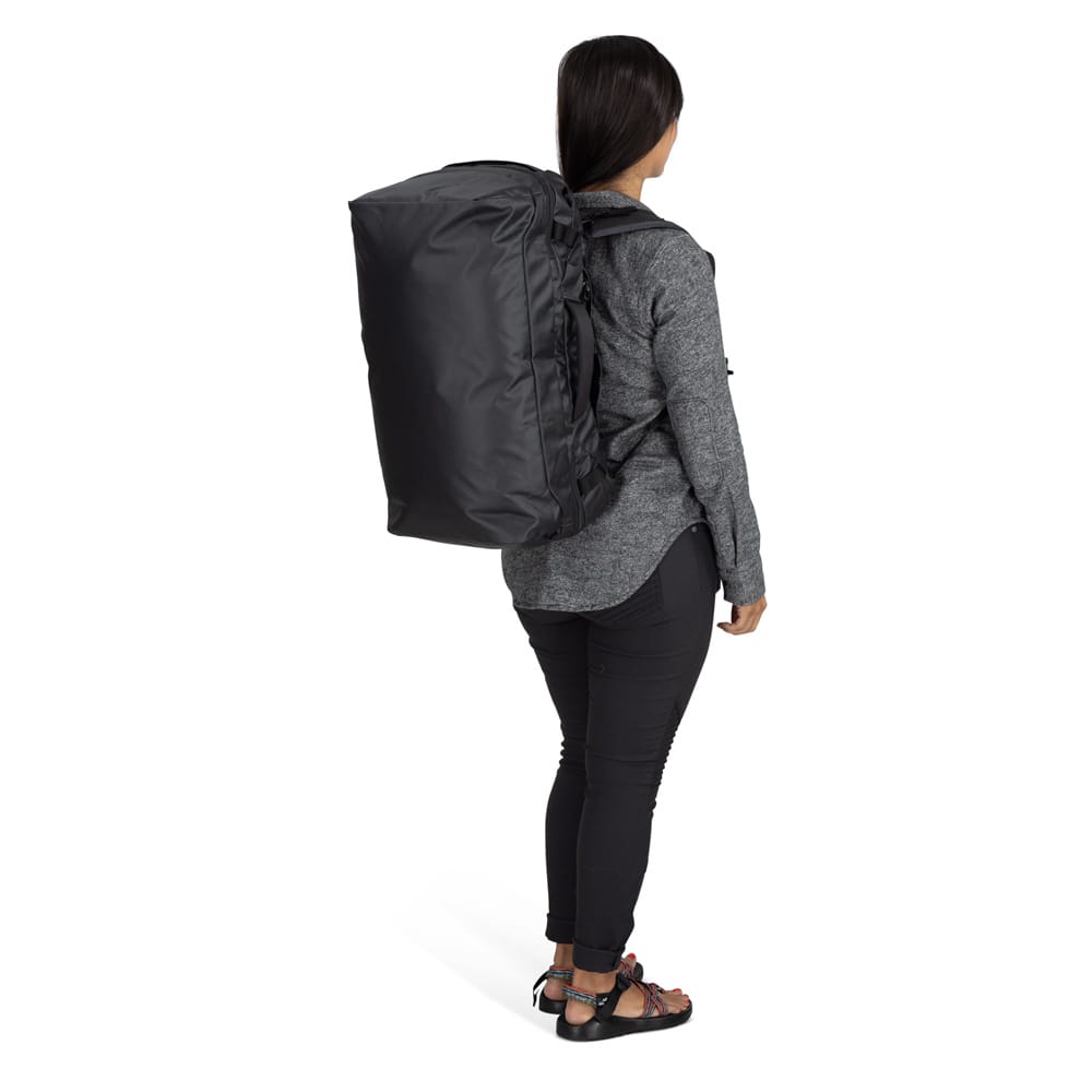en kvinna bär Osprey Transporter Squffel 70L resväska (unisex)