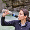 Kvinna dricker ur Sawyer Squeeze vattenfilter.