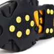 Närbild på halkskydd för skor i svart med gula dubbar SOM ger bra grepp.