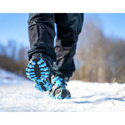 Naturbild på person som går med Nordic grip extreme broddar i snö.