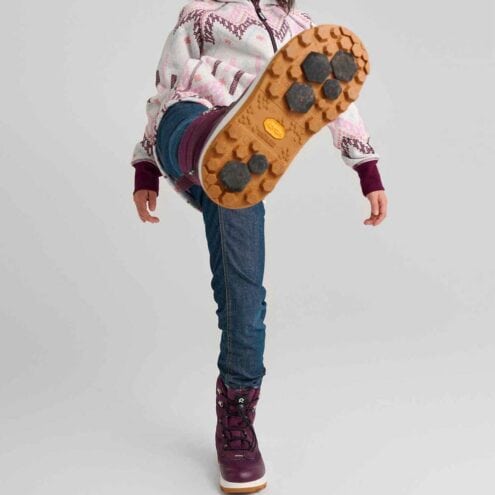 en modell bär Reima Laplander 2.0 vattentäta vinterkängor (barn) och sparkar upp benet