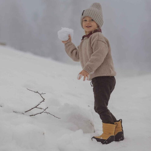 Barn som leker i snön med Kavat Voxna WP stövlar