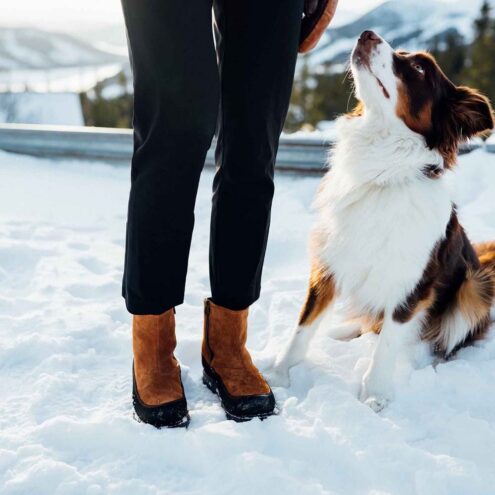 Ett par varma och sköna Kavat Dalum XCS vinterkängor (dam) på en modell som är med en hund