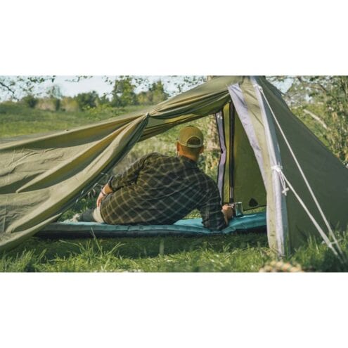 En man sitter i ett Ett hållbart och exlusivt Robens Challanger 3XE tält för 3 personer