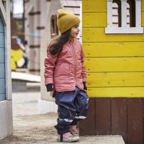 En flicka bär Tretorn Aktiv Fleece Highpants (barn) med en snygg jacka till