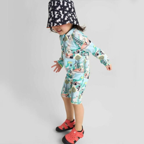 Ett barn har på sig En vattentålig Reima Sandals Koralli sandaler (barn) som är lätt att ta av och på