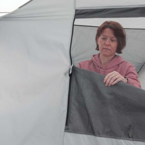 En person använder Easy Camp Camp Shelter kupoltält för 6 personer