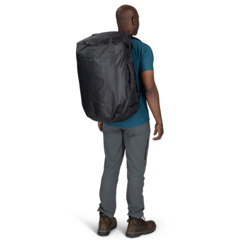 en manlig modell har på sig en Osprey Transporter Duffel 65L (unisex)